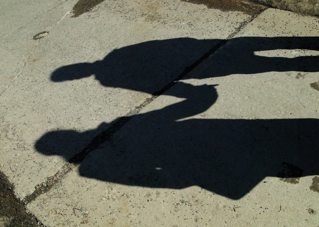 photo of a shadow of two people holding hands