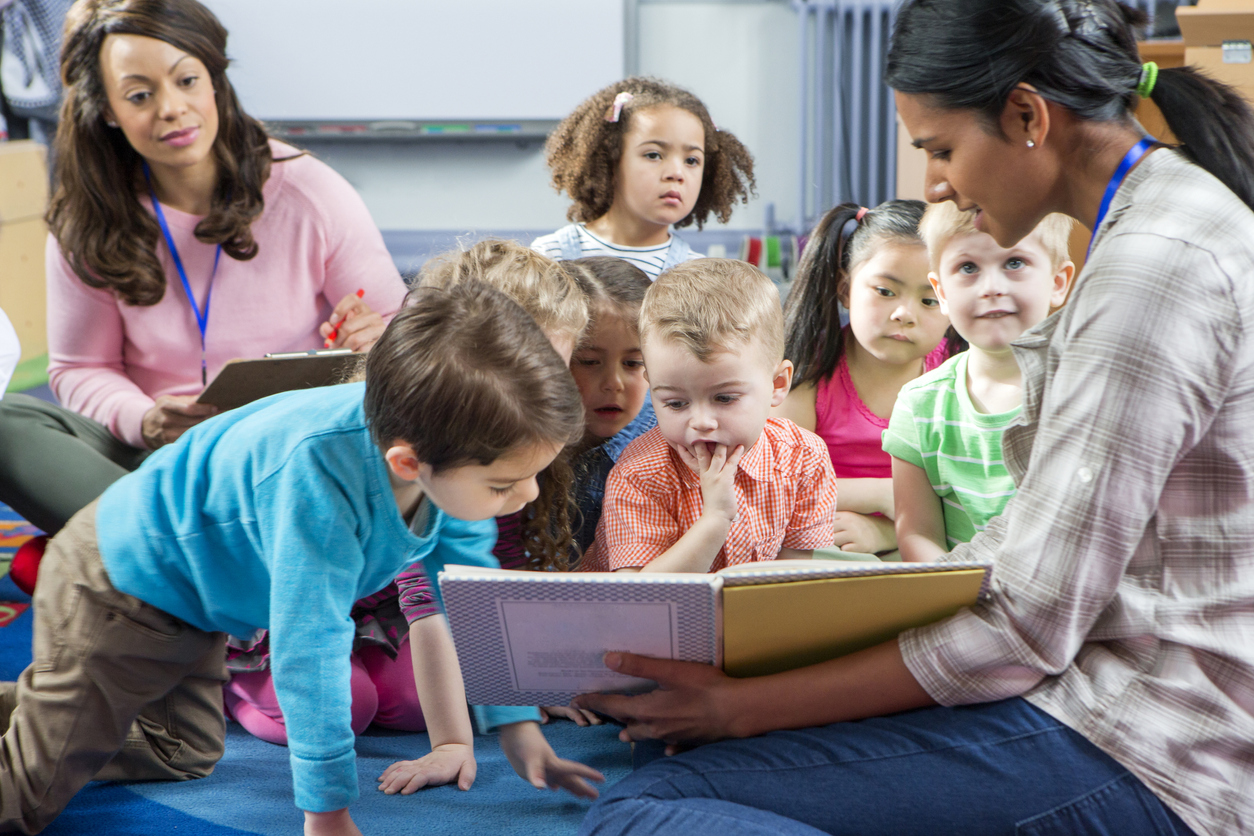 young children listening in storytime and looking at book