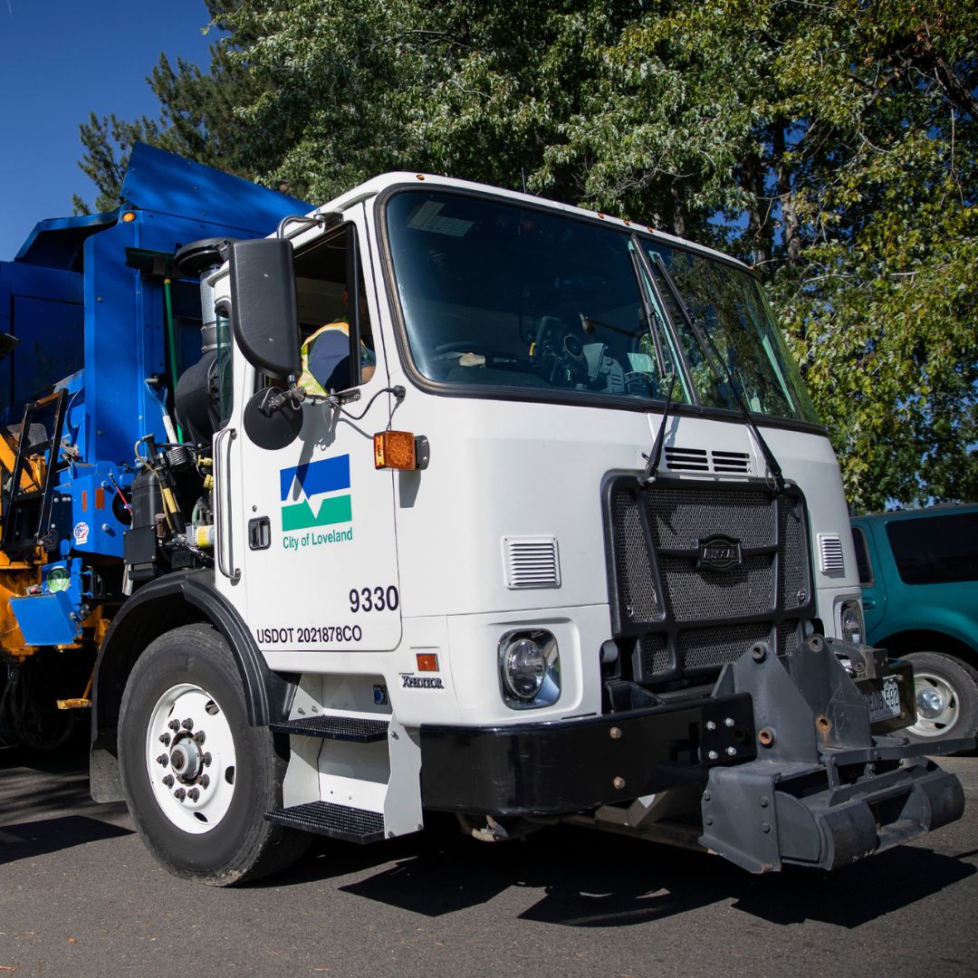 Large City of Loveland branded garbage truck.