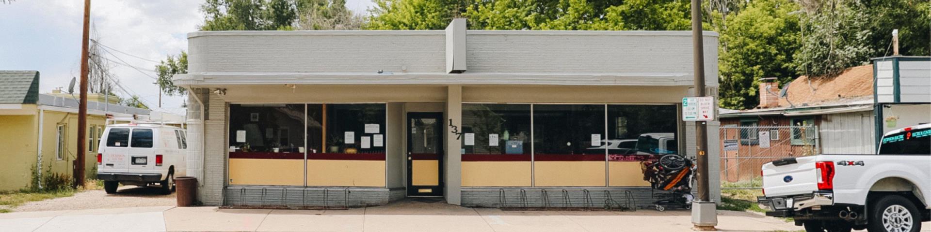 An exterior photo of the Loveland Resource Center. The building has several windows and bike racks along the front.