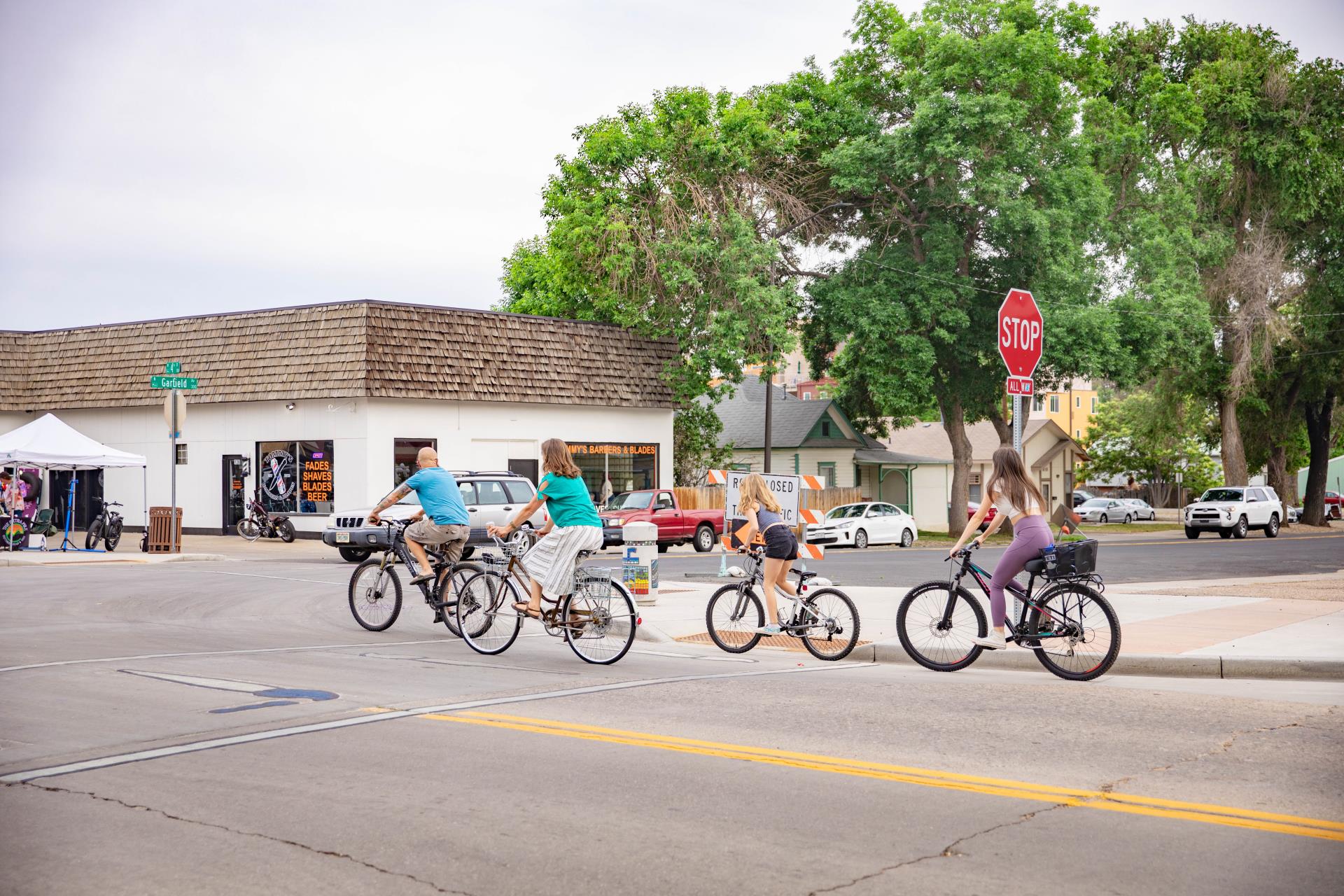 Four people ride their bikes on 4th Street.