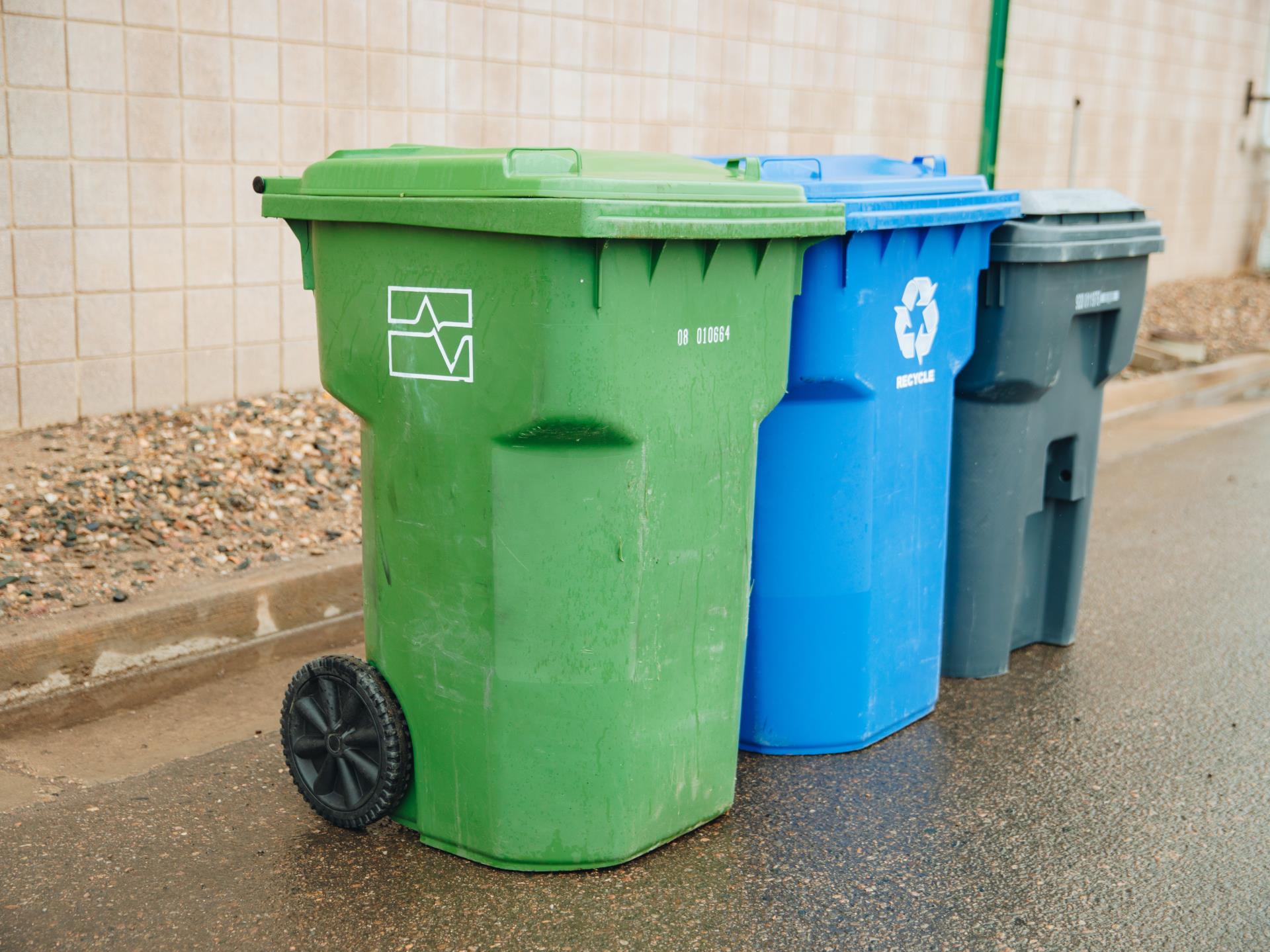 Thee Solid Waste carts lined up on a street.