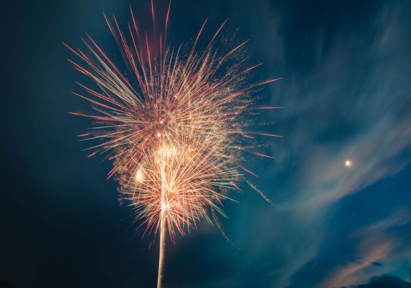 Bright fireworks exploding in the night sky, creating a colorful display.