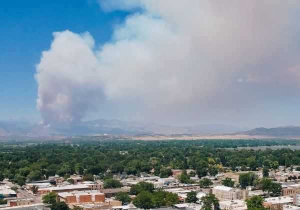 A large cloud of smoke appears in the sky to the west of Loveland.